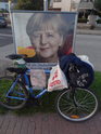 Angela Merkel v době volební kampaně na plakátě stála jakémusi cyklistovi za to, aby si o ni opřel kolo.